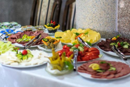 uma mesa com muitos pratos de comida em Hotel Hoti em Ulcinj