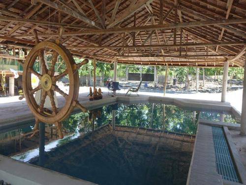 una piscina con una rueda de madera en un edificio en Happy Bear, en Moalboal