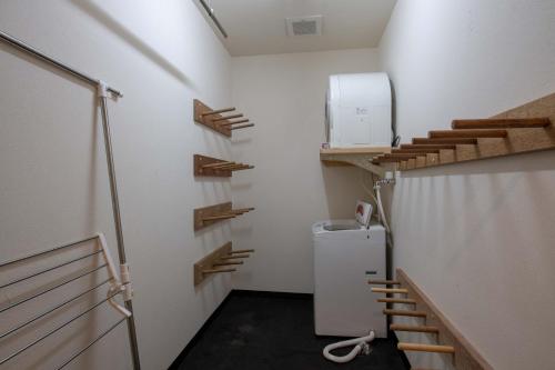 倶知安町にある四季・小雪の小さな客室で、冷蔵庫、木製の棚が備わります。