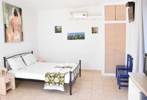 1 dormitorio pequeño con 1 cama y cocina en Kiotari Beach Apartments, en Kiotari