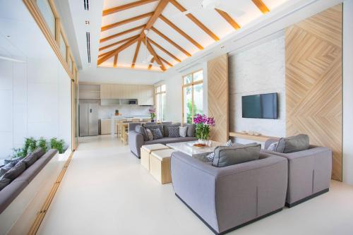 a living room with two couches and a tv at Himmapana Villas - SHA Extra Plus in Kamala Beach