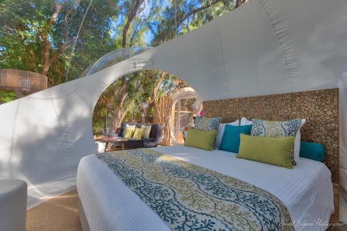 a bedroom with a white bed in a tent at Bubble Lodge Ile aux Cerfs Island in Ile aux Cerfs