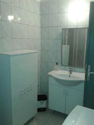 a white bathroom with a sink and a mirror at Starigrad kod Senja 60/a in Starigrad
