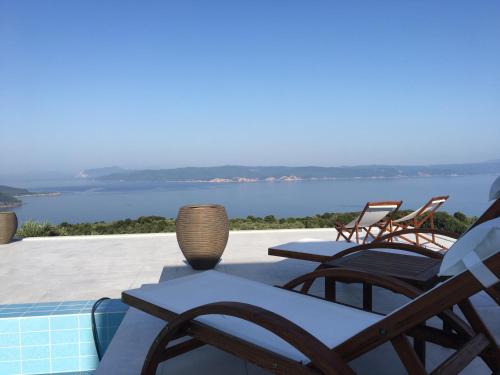 a patio with chairs and a view of the water at Villa Salina Luxury Pool Villa in Kechria