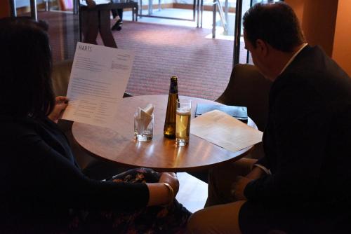 a group of people sitting around a table with a bottle of beer at Hart's Hotel in Nottingham