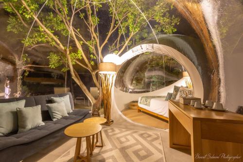 a living room with a couch and a tree mural at Bubble Lodge Ile aux Cerfs Island in Ile aux Cerfs