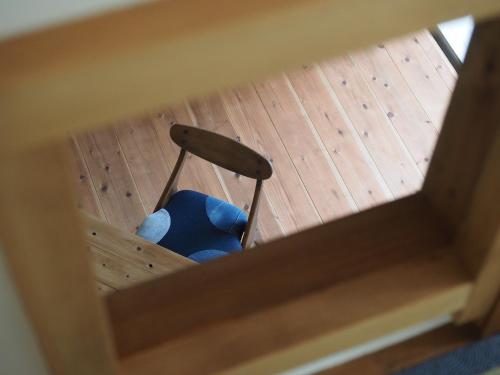 a blue chair sitting on a wooden floor at Oku Cottage - walk to Ohama Beach - Max 4 ppl in Shimoda