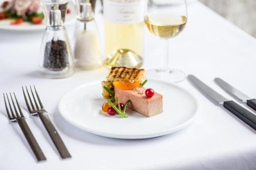 a plate of food on a table with a glass of wine at Hart's Hotel in Nottingham