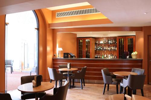a restaurant with tables and chairs and a bar at Hart's Hotel in Nottingham