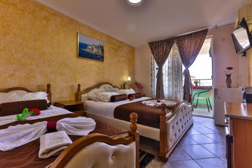 a hotel room with two beds and a balcony at Hotel Hoti in Ulcinj