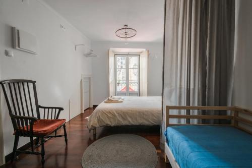 リスボンにあるTouriga 30 - coracao de Alfamaのベッドルーム1室(ベッド1台、椅子、窓付)