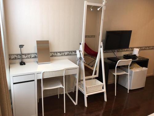 a room with a desk and a computer and a mirror at Business Hotel La Firenze in Tokyo