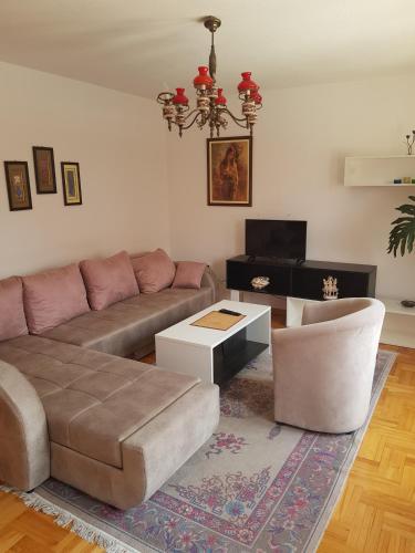 a living room with a couch and a table at Poseidon Apartment - Pool Access & Free Parking in Niš