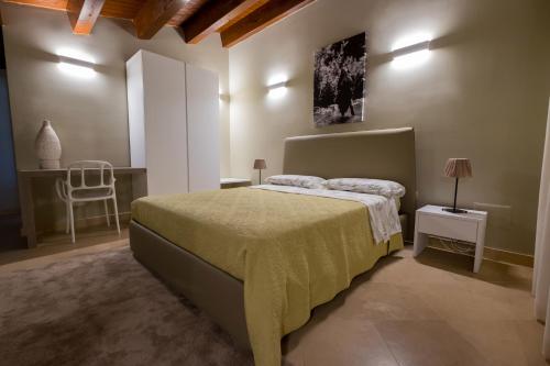a bedroom with a bed and a chair at Domus Hyblaea Resort in Palazzolo Acreide