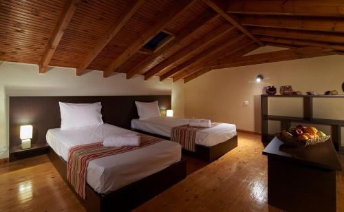 a bedroom with two beds and a bowl of fruit at Caretta Village in Toroni