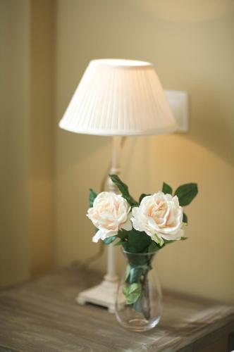 a vase with flowers on a table with a lamp at Ático con amplia terraza Nautilus II - VUT-480-AS in Luanco