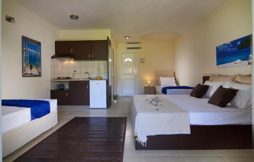a hotel room with two beds and a kitchen at Caretta Village in Toroni