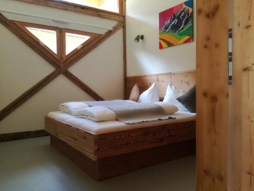 a bed in the corner of a room with a window at Dobringers Chalet-Dorf Warös in Hermagor