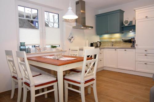 a kitchen with a wooden table and white cabinets at Haffmuschel in Zirchow