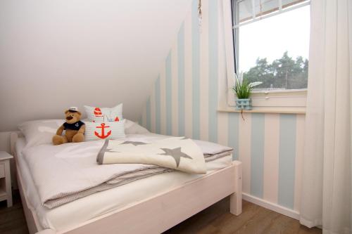 a small bedroom with a bed with a teddy bear on it at Haffmuschel in Zirchow