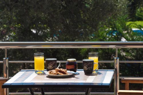 a table with a plate of food and glasses of orange juice at Summer Dream Lefkas in Lefkada Town