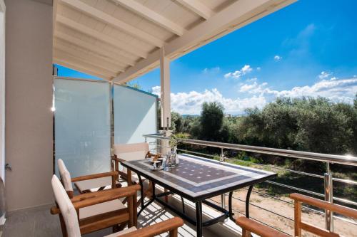 a patio with a table and chairs on a balcony at Summer Dream Lefkas in Lefkada Town