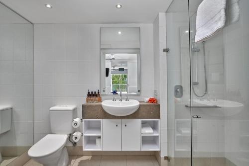a bathroom with a toilet and a sink and a shower at Palm Cove Paradise - Couples spa beach getaway in Palm Cove