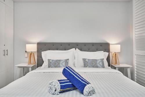 a bedroom with a large white bed with blue pillows at Palm Cove Paradise - Couples spa beach getaway in Palm Cove