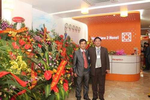 two men standing in front of a flower shop at Van Mieu 2 Hotel in Hanoi