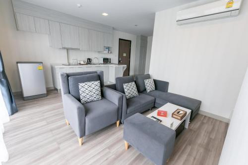 a living room with a couch and two chairs and a table at Locals Prio ChiangMai Central Airport Plaza in Chiang Mai