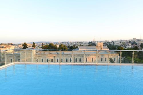 a large swimming pool in front of a building at St. George Hotel in Jerusalem