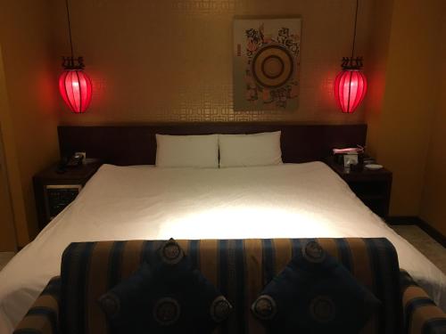 a bedroom with a large bed with two red lights at Hotel Cuna Kyoto Love Hotel in Kyoto