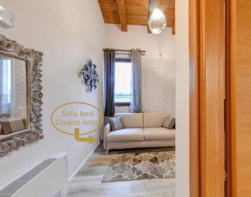 ein Wohnzimmer mit einem Sofa und einem Spiegel in der Unterkunft Agriturismo CAMPANELLA in Sossano