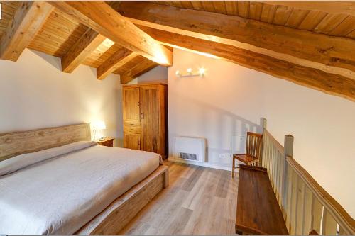 ein Schlafzimmer mit einem großen Bett und Holzdecken in der Unterkunft Agriturismo CAMPANELLA in Sossano