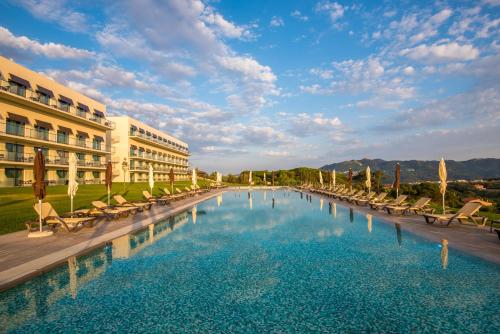 a large swimming pool with chairs and a building at Vila Gale Collection Sintra in Sintra