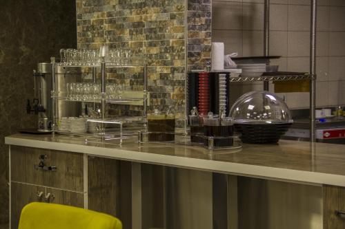 a glass counter with glasses and a yellow chair at Ayder Şimşir Butik Otel in Ayder Yaylasi