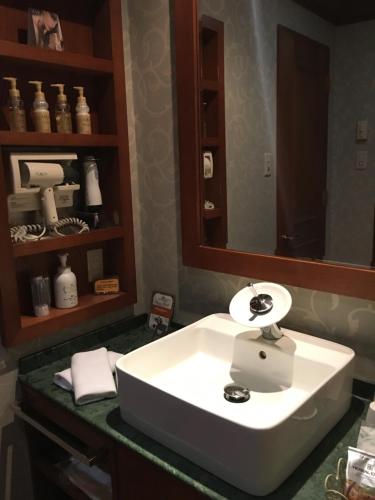 a bathroom with a white sink and a mirror at Hotel Cuna Kyoto Love Hotel in Kyoto