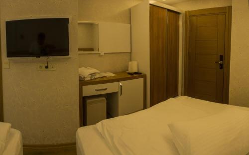 a hotel room with a bed and a flat screen tv at Ayder Şimşir Butik Otel in Ayder Yaylasi