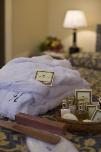 a basket of towels and candles on a bed at Hotel Savoy in Pesaro