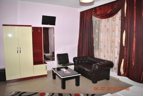 a living room with a leather couch and a coffee table at Hotel Freskia in Gjirokastër
