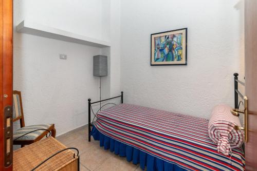 a bedroom with a bed with a striped blanket at Casale Gli Ulivi in Orbetello