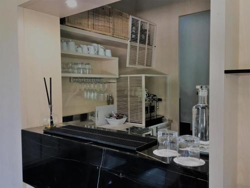 a kitchen with a counter with glasses on it at Archeo Hotel in Gela
