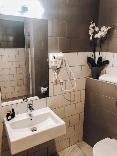 a bathroom with a sink and a mirror at poznańska19 in Nowy Tomyśl