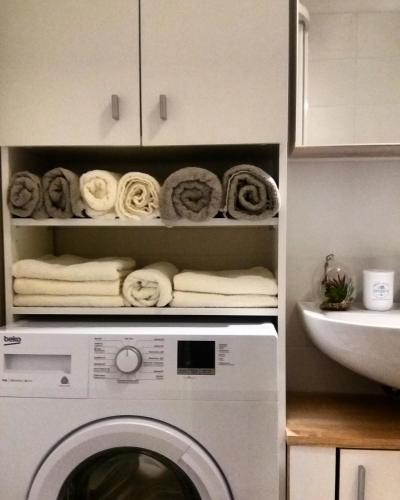 a white washing machine in a kitchen with towels at Brunetti Suite Zlín in Zlín