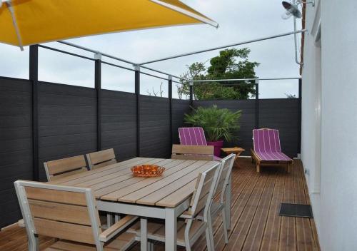 une table et des chaises en bois sur une terrasse dans l'établissement CotiLoft - Appartement Terrasse climatisé au cœur de La Cotinière, à La Cotinière