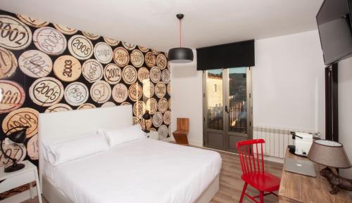 a bedroom with a white bed and a wall with plates at La Casita de la Planta in Quintanilla de Onésimo