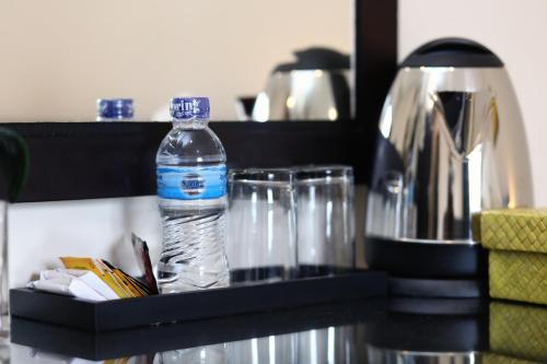 a bottle of water sitting on a table with glasses at Cameng Homestay in Denpasar