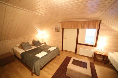 NuorgamにあるVilla Nuorgamのベッドルーム1室(ベッド1台付)、窓が備わります。