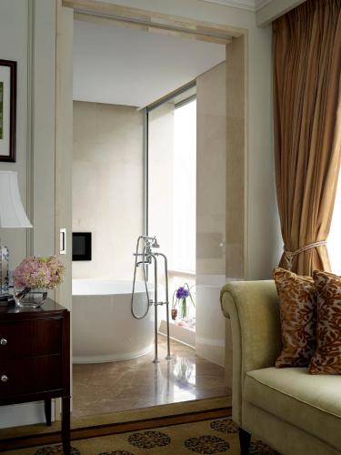 a living room with a bath tub and a couch at The Langham, Shenzhen in Shenzhen