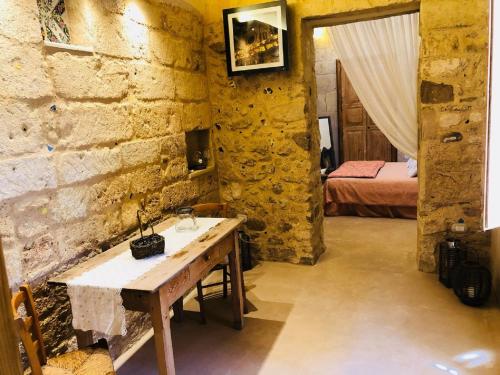 een kamer met een stenen muur met een tafel en een bed bij Borgo in corte in Martano